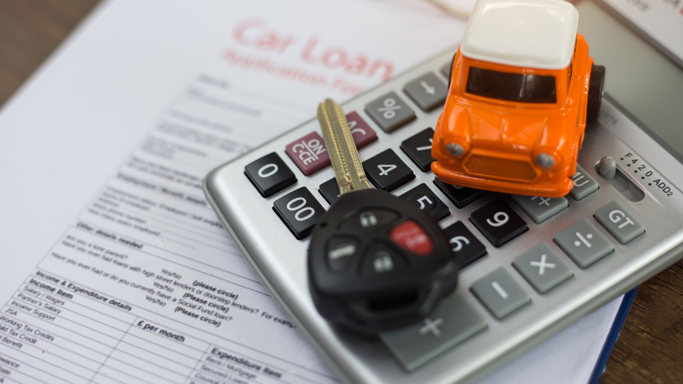car loan paperwork with calculator and car key
