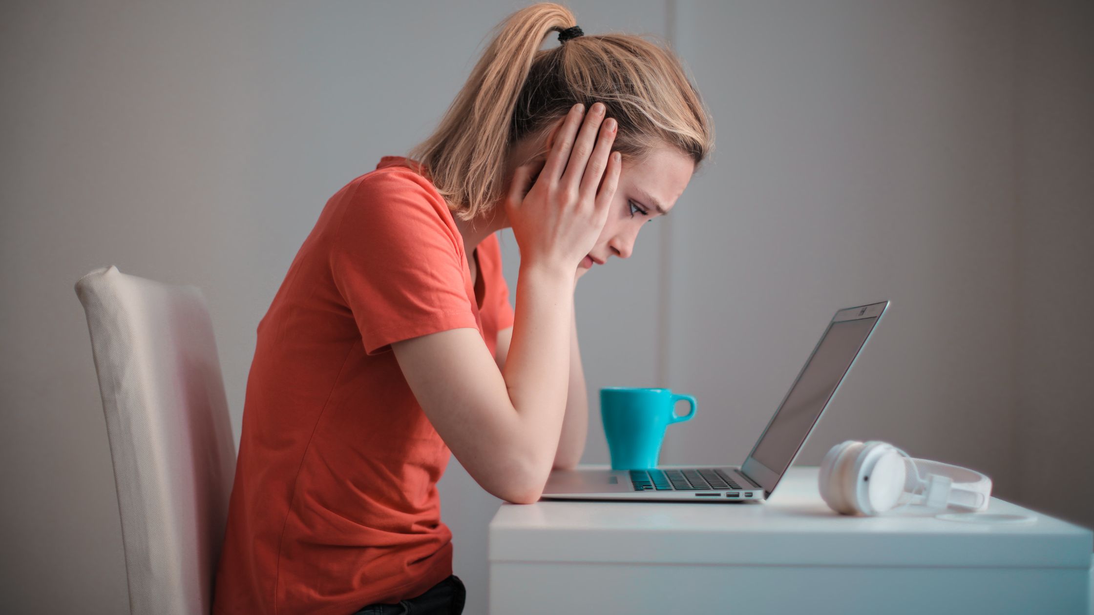 person disappointed leaning over computer